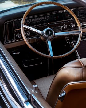 Detailed view of a classic Pontiac car steering wheel and dashboard interior.