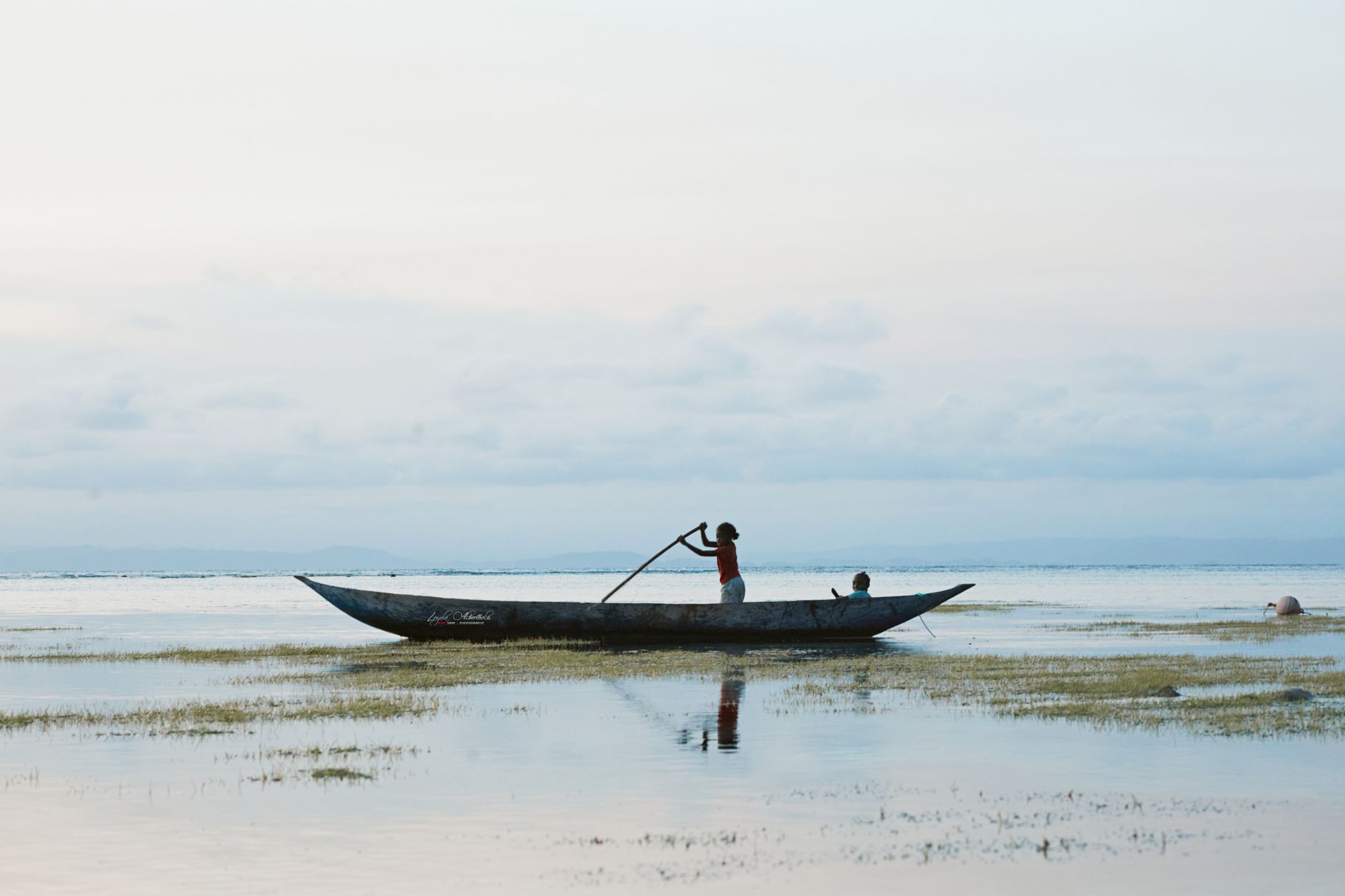 A serene canoe journey in the shallow waters of Madagascar, highlighting local traditions.