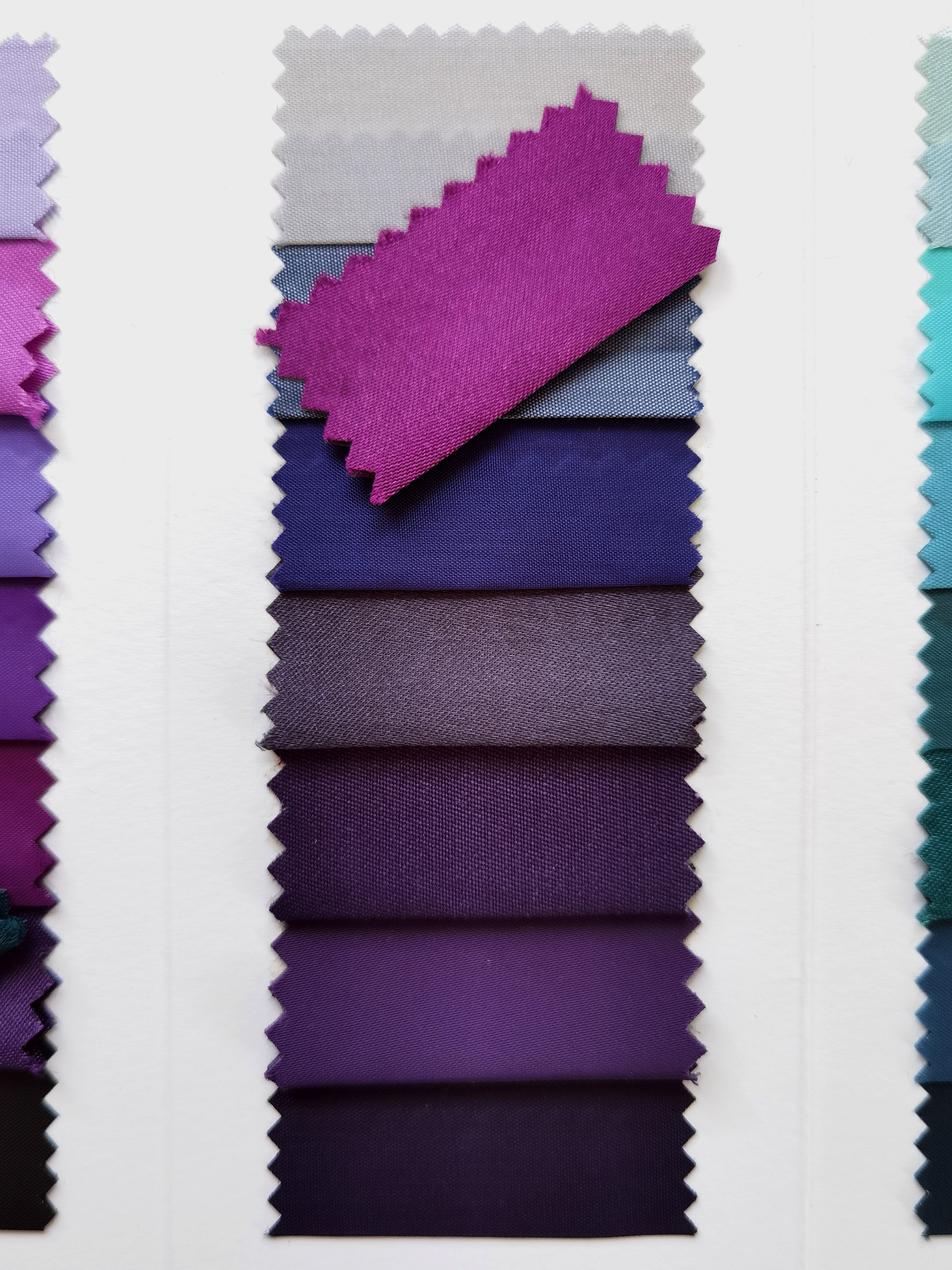 A selection of fabric swatches in different shades of purple, arranged vertically for textile design.