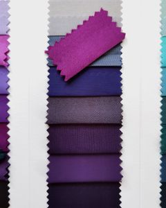 A selection of fabric swatches in different shades of purple, arranged vertically for textile design.