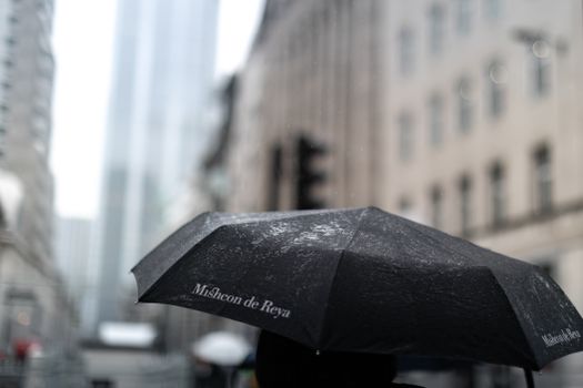 Close-up of a black umbrella on a rainy day in London's city center.