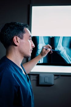 A healthcare professional examining a patient's x-ray in a medical setting.