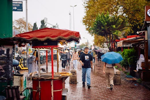 A bustling street in Istanbul during rain with people and street vendors.