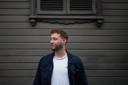 Free A casual portrait of a man standing against a wooden wall in İstanbul, Türkiye. Stock Photo
