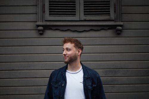 Free A casual portrait of a young man standing against a traditional wooden wall in Istanbul, Türkiye. Stock Photo