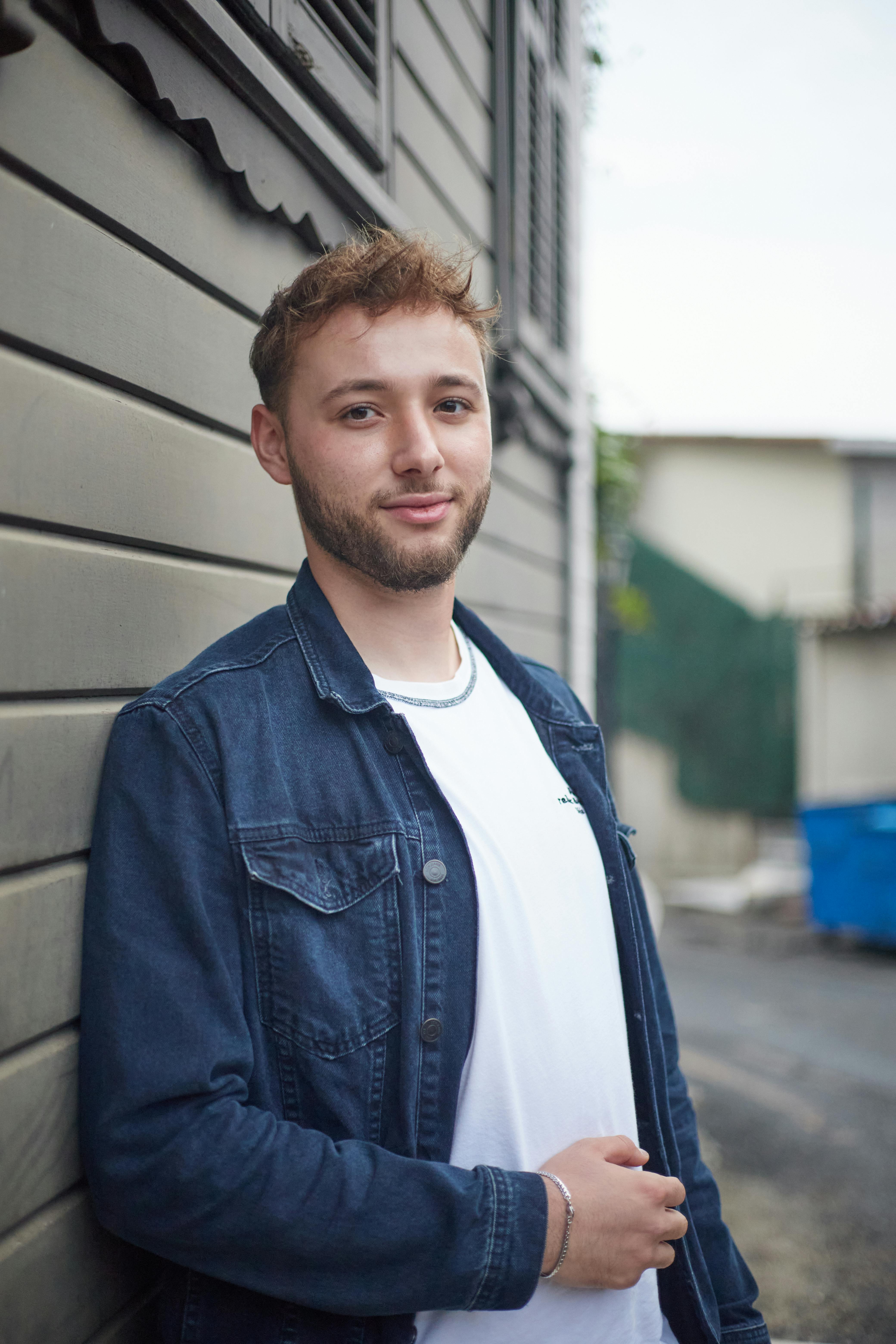 Young man posing casually against a wall in an Istanbul neighborhood.