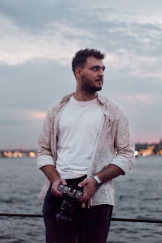Young man with camera at sunset by the Bosphorus in Istanbul.