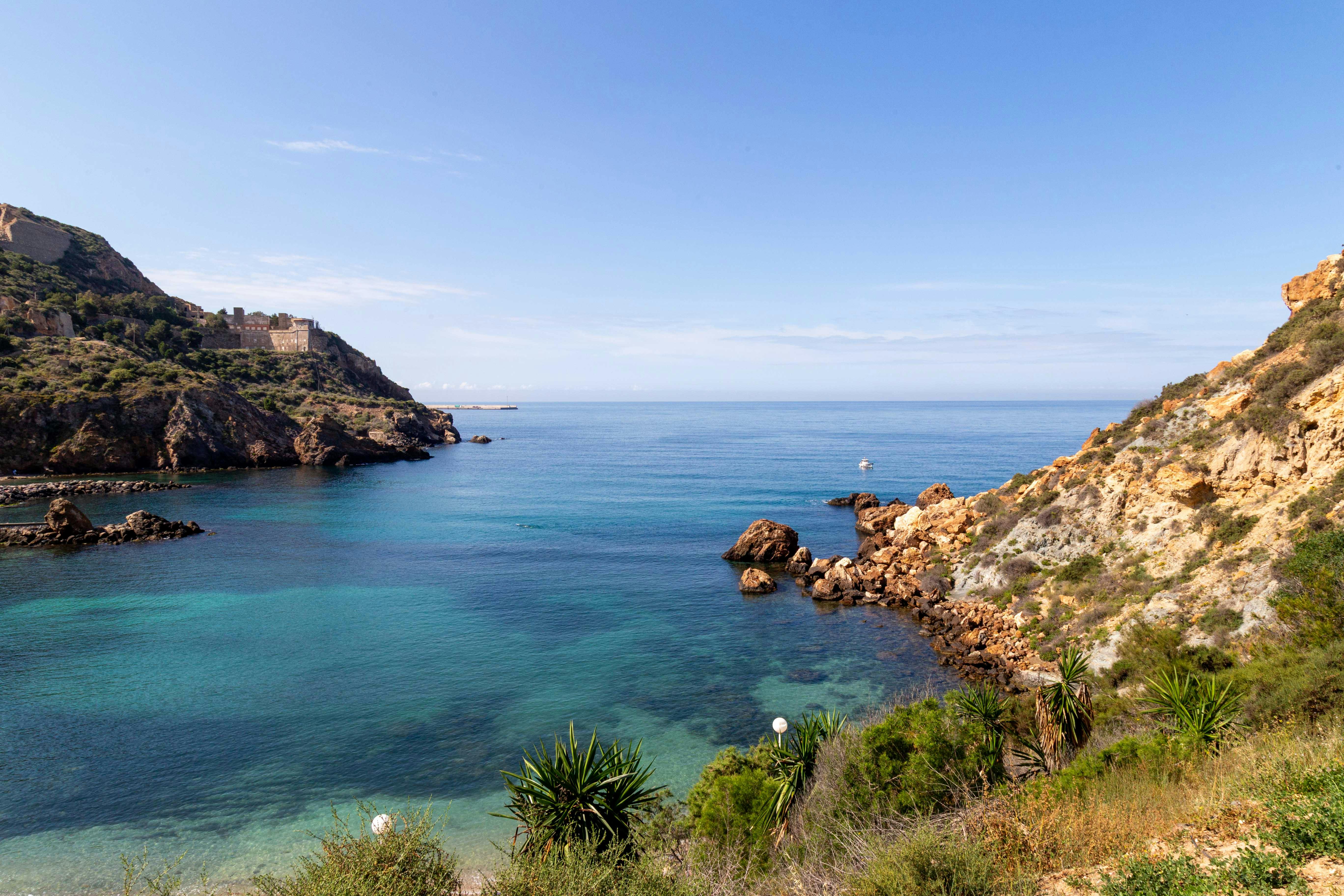 Scenic view of a rocky coastal landscape in Murcia, Spain with clear blue waters and greenery.