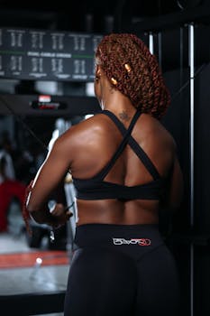 Fit woman lifting weights at the gym, focusing on workout.