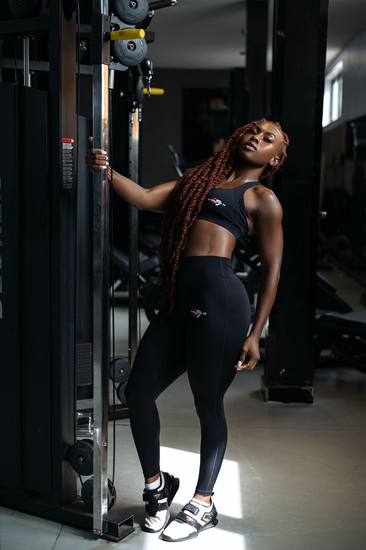 Confident athlete standing beside modern gym training equipment