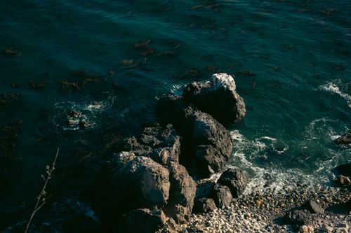 Free A mesmerizing view of ocean waves crashing against rocky cliffs under vibrant daylight. Stock Photo