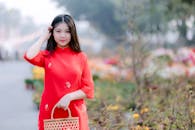 Young Woman in Red Ao Dai in a Flower Garden