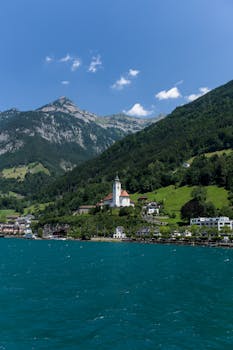 Picturesque Swiss village by the lake with mountain backdrop.