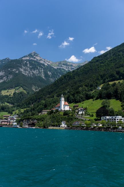 Picturesque Swiss village by the lake with mountain backdrop.