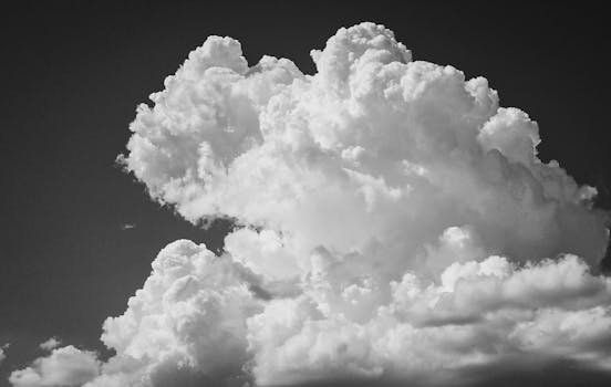 Captivating black and white photo of billowing cumulonimbus clouds against the sky.