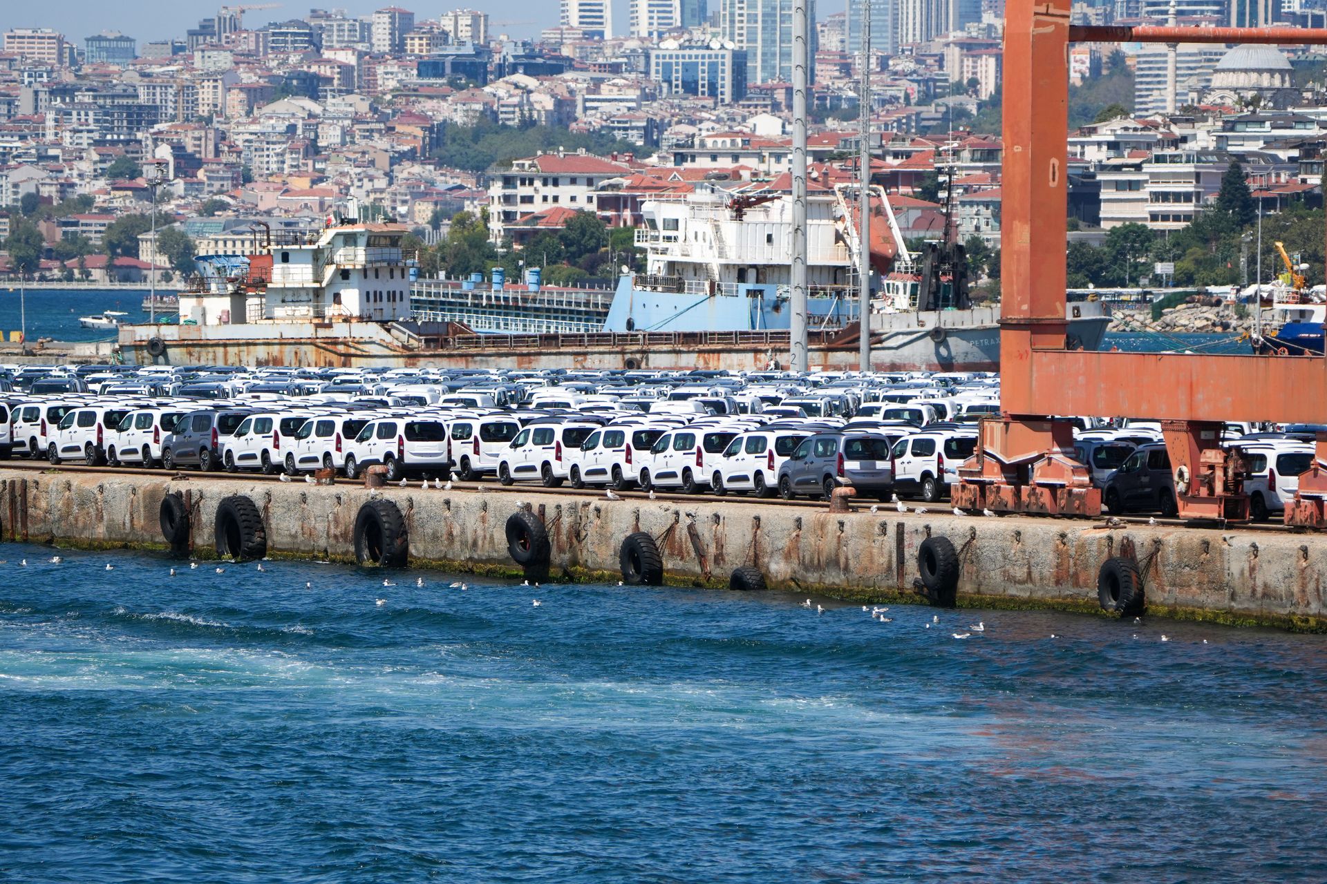 Un buque de carga embarcando coches nuevos en un puerto de día