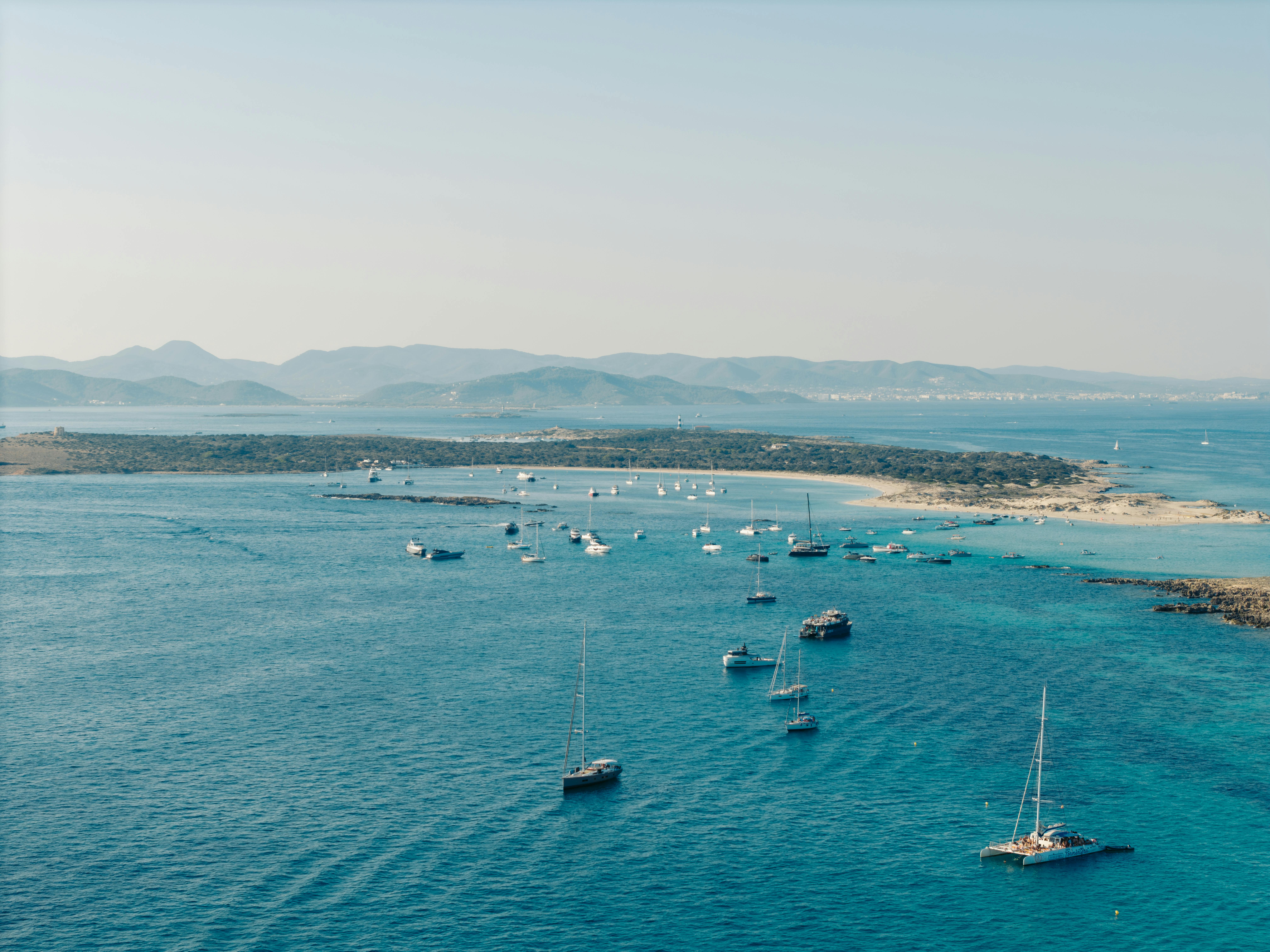 Discover a tranquil summer scene with sailboats near Formentera, Balearic Islands.