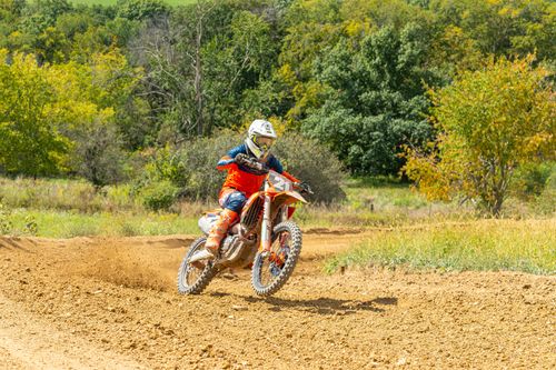 Free Motorcyclist racing on a dirt track through green scenery in Pennsylvania. Stock Photo