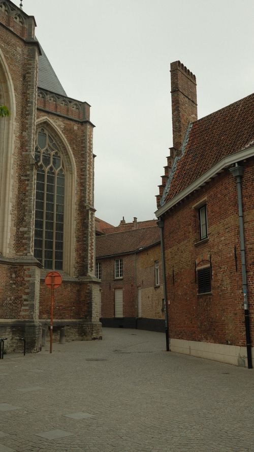 Free A scenic view of classic European architecture with a Gothic church in an empty street. Stock Photo