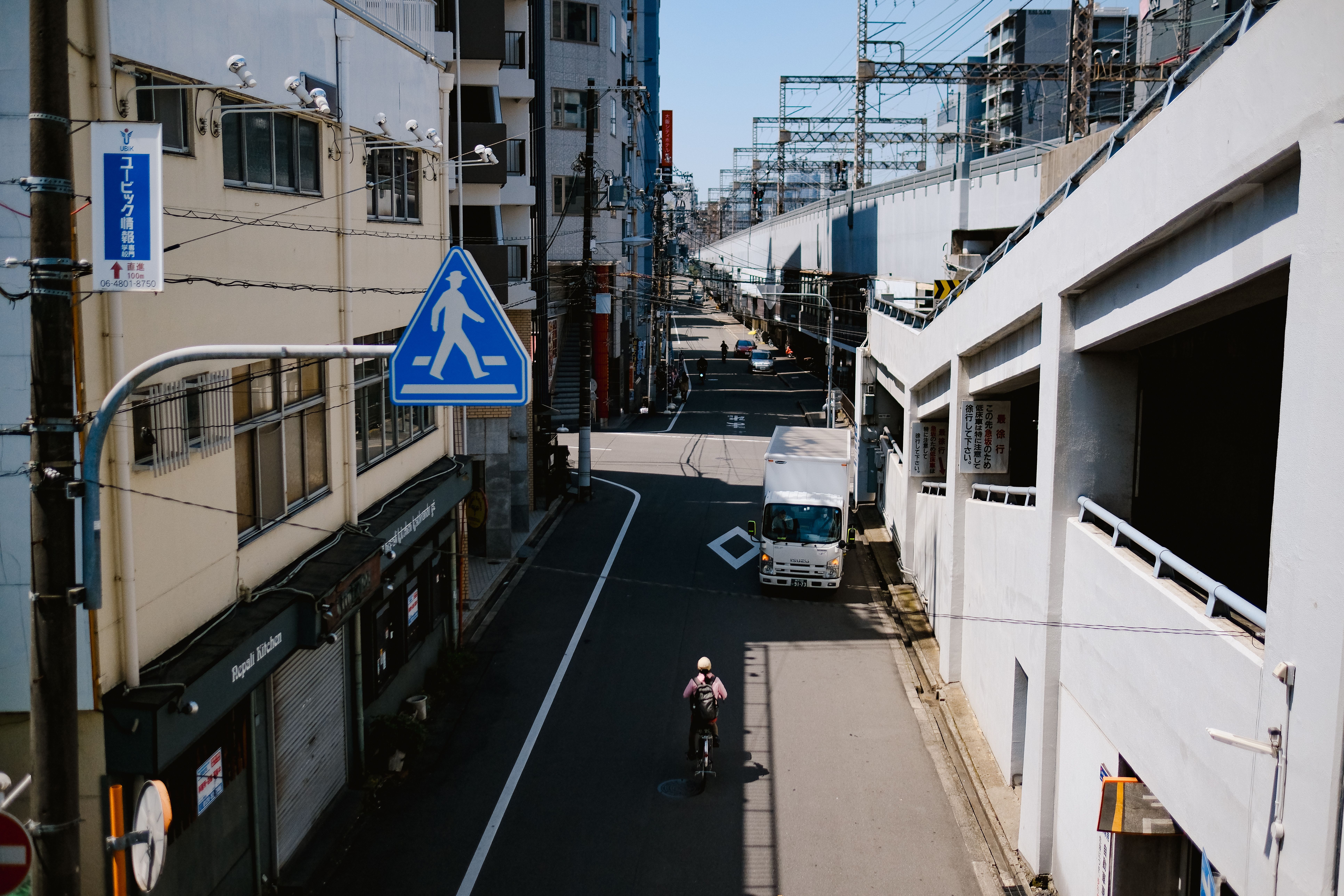Urban street scene with cyclist and truck under sunlight · Free Stock Photo