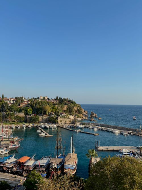 Free Beautiful view over Antalya's historic harbor, featuring boats and Mediterranean Sea under a clear blue sky. Stock Photo