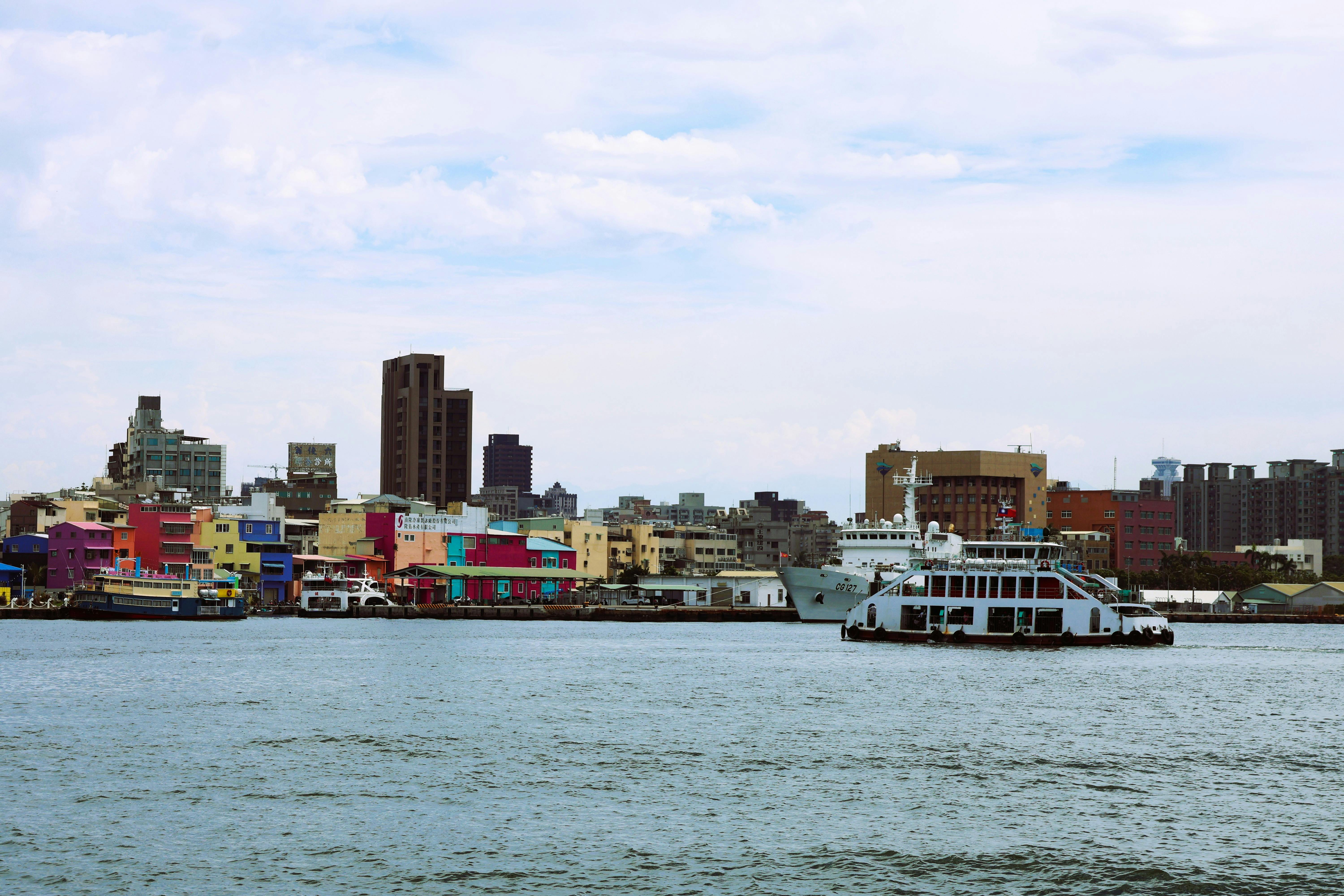 Colorful waterfront view of Kaohsiung, Taiwan with ferry crossing the harbor