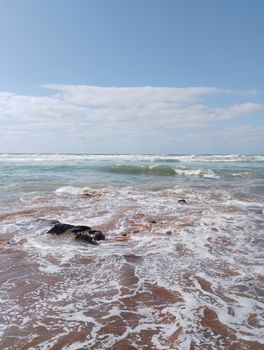 Waves gently lapping at the shore under a clear sky at Casablanca beach.