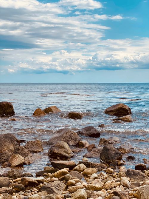 Free Explore the serene rocky beach of Plymouth, Massachusetts with cloudy skies and Atlantic Ocean waves. Stock Photo