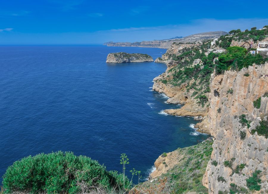 A breathtaking view of the rugged coastal cliffs and blue sea in Jávea, Spain.