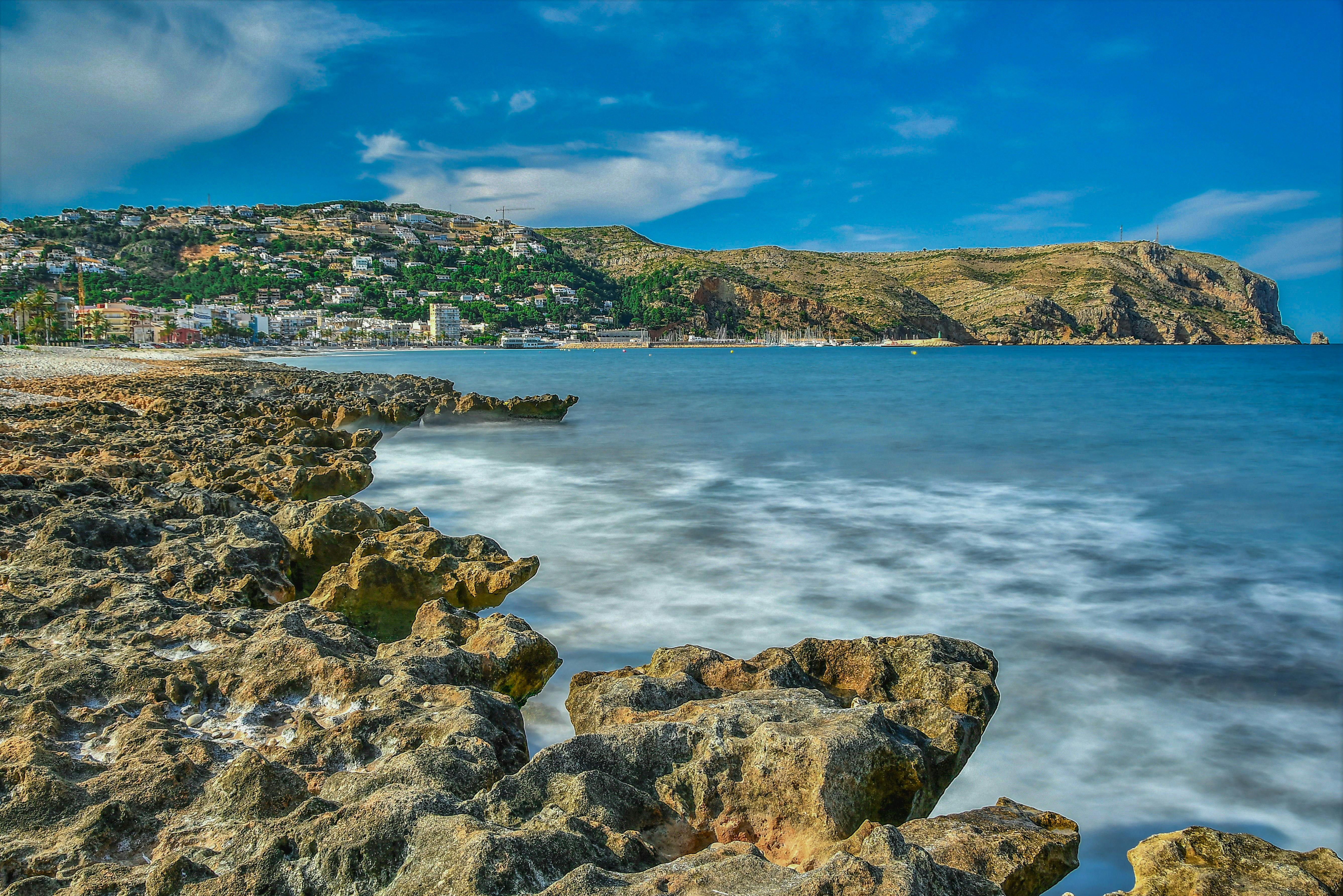 Stunning coastal landscape of Jávea, Spain with rocky shoreline and vibrant blue waters.
