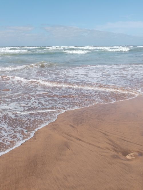 Free Peaceful beach scene in Casablanca with gentle waves and sandy shore. Stock Photo