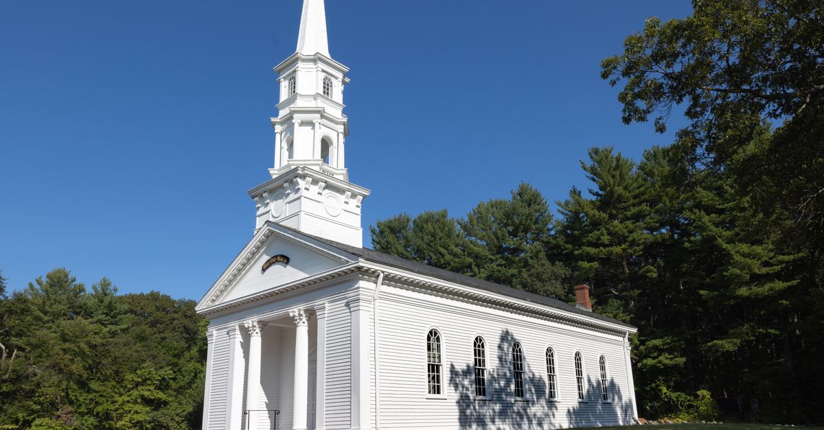Charming white church with steeple surrounded by trees in Sudbury, Massachusetts.