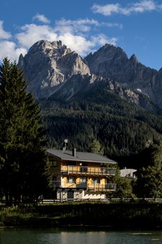 Alpine chalet with breathtaking mountain backdrop under a clear blue sky.
