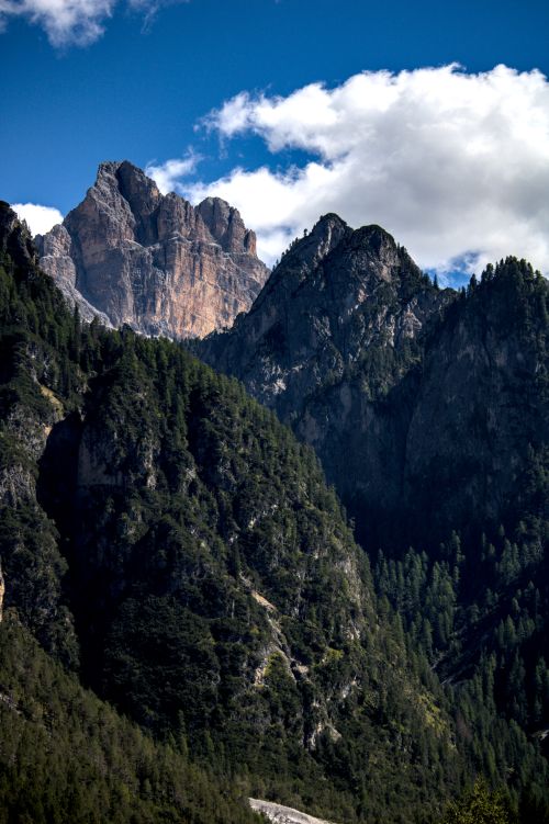 Free Breathtaking view of the rugged Dolomites peaks against a vibrant blue sky with fluffy clouds. Stock Photo