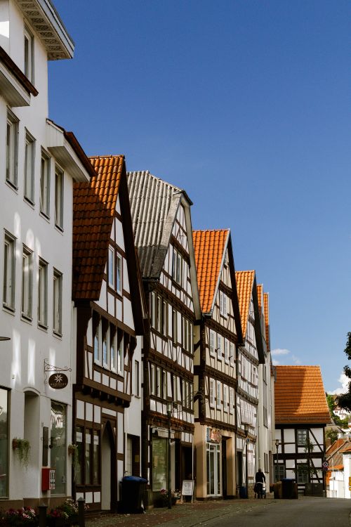 Free Picturesque street view of traditional half-timbered houses with bright blue sky. Stock Photo