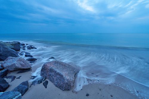 Free Long exposure of waves crashing on the rocky beach in Hjørring, Denmark during twilight. Stock Photo