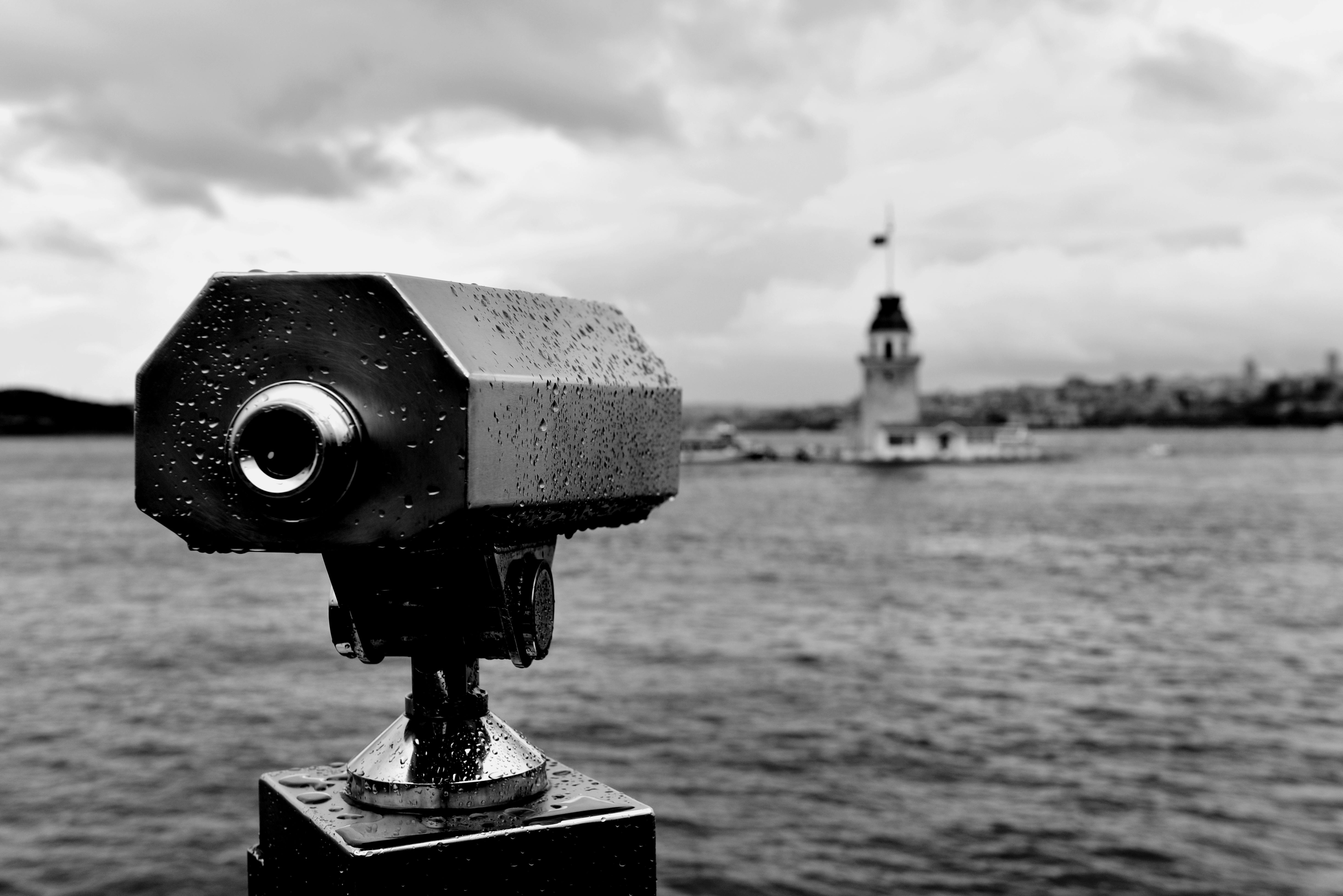 Monochrome photo of Maiden's Tower in Istanbul seen through a telescope across the water.