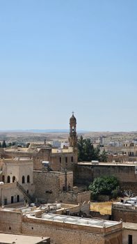 Explore the historic cityscape featuring ancient stone buildings under a clear blue sky.