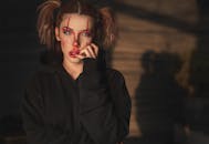 一位女性的艺术肖像，面部彩绘富有表情，并融入了皮影戏元素，营造出一种喜怒无常且戏剧性的氛围