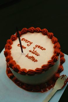 A creatively decorated cake with a funny message 'Every Year Hotter', perfect for a playful birthday celebration.