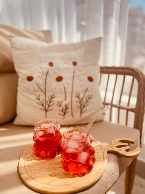 Free Chilled red beverages on a cozy wooden balcony setting with floral decor. Stock Photo