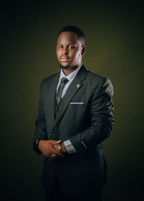 Free A confident businessman wearing a suit, captured in a studio with a dark background. Stock Photo