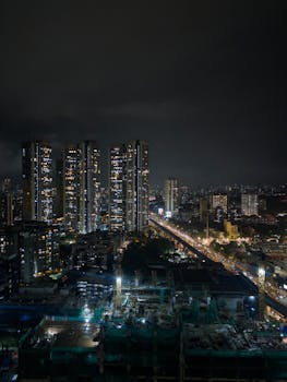 Stunning night view of a city's illuminated skyline with bustling streets below.