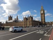 伦敦一个阳光明媚的日子里，大本钟和威斯敏斯特宫与车流和行人相映成趣