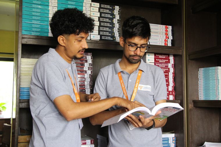 طلاب يناقشون مواد دراسية في المكتبة