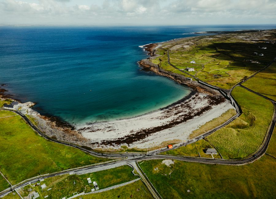 Stunning aerial view of the picturesque coastline in County Clare, Ireland featuring lush greenery and blue ocean.