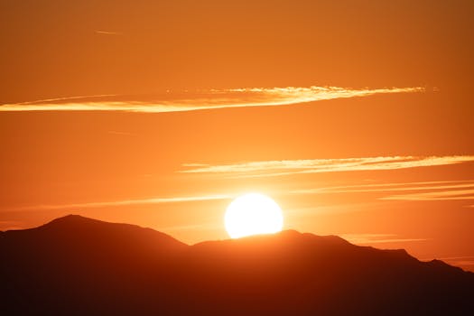 Captivating sunrise casting warm hues over mountain peaks and glowing sky.