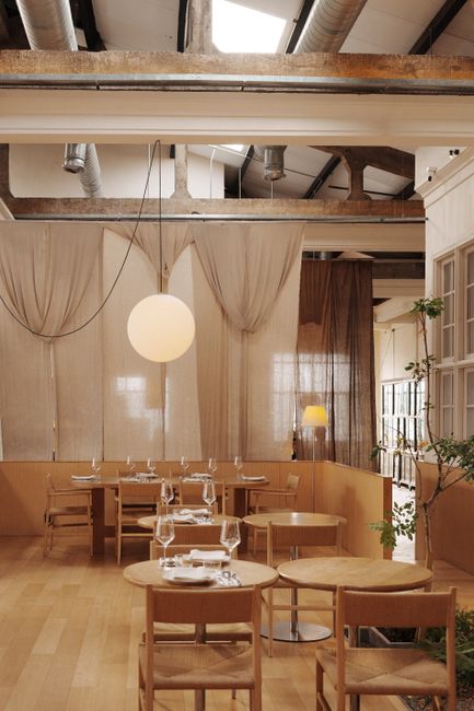 Chic industrial-style restaurant interior with wooden furniture and ambient lighting in George Town, Malaysia.