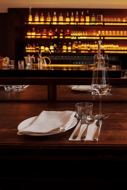 Free Close-up of a finely set dining table with glassware in a cozy bar setting. Stock Photo