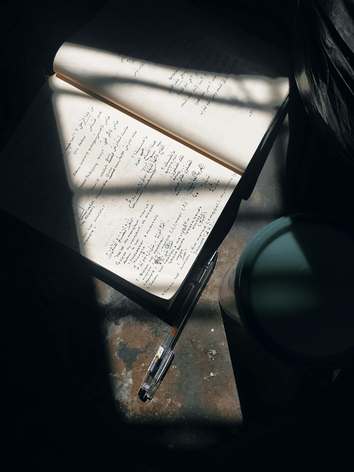 Taccuino aperto con penna illuminato dalla luce del mattino sul tavolo